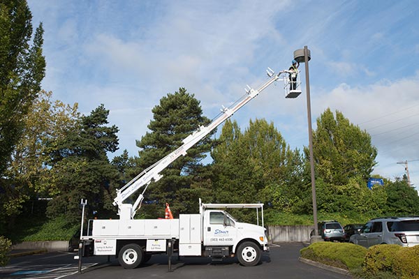 Lighting Services Tech working on exterior fixture Lighting Services Tech working on exterior fixture image